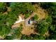 Aerial view showcasing a house with a solar panel surrounded by lush greenery and mature trees at 19266 Campground Rd, Brooksville, FL 34601