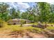 An expansive backyard with solar panels, a patio, a fire pit, and a charming shed at 19266 Campground Rd, Brooksville, FL 34601