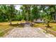 Enjoy outdoor gatherings in this spacious backyard, complete with a brick patio and a cozy fire pit area at 19266 Campground Rd, Brooksville, FL 34601