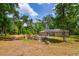 Tranquil backyard featuring a solar-paneled house, fire pit, and ample green space at 19266 Campground Rd, Brooksville, FL 34601