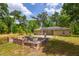 Backyard of a cozy home featuring a patio area, fire pit, and solar panels on the roof at 19266 Campground Rd, Brooksville, FL 34601