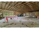 Spacious barn interior featuring a concrete floor, exposed wooden beams, and ample natural light at 19266 Campground Rd, Brooksville, FL 34601