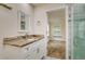 Bathroom with granite countertop, white cabinetry, and an open view to the bedroom at 19266 Campground Rd, Brooksville, FL 34601