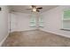 Bright bedroom with a ceiling fan, neutral carpet, and plenty of natural light at 19266 Campground Rd, Brooksville, FL 34601