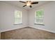 Inviting bedroom featuring soft carpet and abundant natural light from two large windows at 19266 Campground Rd, Brooksville, FL 34601