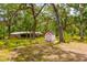 Spacious property featuring a house, shed, and lush green surroundings with mature trees at 19266 Campground Rd, Brooksville, FL 34601