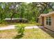 View of a house with mature trees and an outbuilding in the back at 19266 Campground Rd, Brooksville, FL 34601