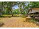 A glimpse of the home, barn, and shed nestled in a lush, grassy, tree-filled landscape at 19266 Campground Rd, Brooksville, FL 34601