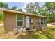 The house's side, equipped with solar panels and modern utilities against a green backdrop at 19266 Campground Rd, Brooksville, FL 34601
