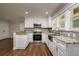 Renovated kitchen with granite countertops, stainless steel appliances, and a farmhouse sink at 19266 Campground Rd, Brooksville, FL 34601
