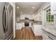Well-lit kitchen with granite counters, stainless steel appliances, and wood flooring at 19266 Campground Rd, Brooksville, FL 34601