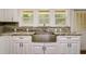 Close-up of a stainless steel farmhouse sink with granite countertops and white cabinets at 19266 Campground Rd, Brooksville, FL 34601
