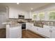 Bright kitchen with white cabinets, granite countertops, and stainless steel appliances at 19266 Campground Rd, Brooksville, FL 34601