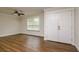 Bright living room with wood-look flooring, ceiling fan, and double door entry at 19266 Campground Rd, Brooksville, FL 34601