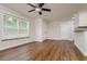 Spacious living room with ceiling fan, wood floors, and abundant natural light at 19266 Campground Rd, Brooksville, FL 34601
