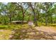 An exterior of the property with a red and white shed surrounded by trees at 19266 Campground Rd, Brooksville, FL 34601