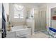 Bright bathroom featuring a soaking tub, a glass enclosed shower, and a stylish window treatment at 19528 Sunset Bay Dr, Land O Lakes, FL 34638
