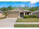 Charming single-story home featuring a well-manicured lawn and attached two-car garage at 19528 Sunset Bay Dr, Land O Lakes, FL 34638