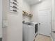Modern laundry room with washer, dryer, and storage shelves at 19528 Sunset Bay Dr, Land O Lakes, FL 34638