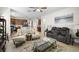 Open concept living room featuring ample seating, modern decor, and seamless kitchen views at 19528 Sunset Bay Dr, Land O Lakes, FL 34638