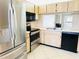Kitchen with stainless steel appliances, wood cabinets, and views into the living room at 2024 Blue Hawk Ct # 1822, Clearwater, FL 33762
