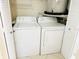A laundry closet with both washer and dryer with utility shelving at 2024 Blue Hawk Ct # 1822, Clearwater, FL 33762