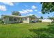 Back of house has large green backyard with lush grass and a small patio area at 2060 Attache Ct, Clearwater, FL 33764