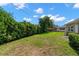 View of backyard featuring lush lawn, mature trees, and partial fencing for added privacy at 2060 Attache Ct, Clearwater, FL 33764