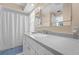 Bright bathroom features a large vanity and a bathtub with shower at 2060 Attache Ct, Clearwater, FL 33764