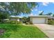 Charming single-story home with a well-manicured lawn, mature trees, and a two-car garage at 2060 Attache Ct, Clearwater, FL 33764