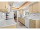 Clean kitchen with white tile flooring and appliances, offering a practical cooking space at 2060 Attache Ct, Clearwater, FL 33764