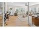 Bright living room with lots of windows featuring a comfortable neutral sofa, ceiling fan, and light-colored hardwood floors at 2060 Attache Ct, Clearwater, FL 33764
