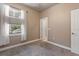 Well-lit bedroom features a window with blinds, neutral carpet and walls, and easy access to the bathroom at 2253 Central Ave # 206, St Petersburg, FL 33713