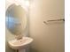 Half-bath features pedestal sink and large round mirror at 2453 Edgewater Falls Dr, Brandon, FL 33511