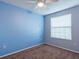 This is a carpeted bedroom with a ceiling fan and a window bringing in natural light at 2453 Edgewater Falls Dr, Brandon, FL 33511