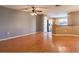 An empty living room boasting wood floors, a ceiling fan, and natural light, creating a versatile space at 2453 Edgewater Falls Dr, Brandon, FL 33511