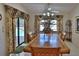 Bright dining room featuring a large wooden table, floral curtains, and a view of the outdoor pool at 2642 Meadow Wood Dr, Clearwater, FL 33761