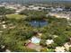 Aerial shot of the community featuring a pond, pool, tennis courts, mature trees and lush landscape at 2722 11Th Ct # 50A, Palm Harbor, FL 34684