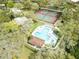 Aerial view showcasing a community pool, tennis courts, and surrounding lush greenery at 2722 11Th Ct # 50A, Palm Harbor, FL 34684