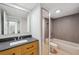 Modern bathroom with a dark vanity countertop, updated fixtures, a large mirror, and a shower over tub at 2722 11Th Ct # 50A, Palm Harbor, FL 34684
