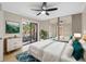 Cozy bedroom featuring mirrored closets, balcony access, neutral paint, ceiling fan, and modern furnishings at 2722 11Th Ct # 50A, Palm Harbor, FL 34684