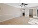 Spacious bedroom with tile flooring, fan, and natural light, with a view to a partial bathroom and walk-in closet at 2722 11Th Ct # 50A, Palm Harbor, FL 34684
