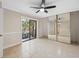 Spacious bedroom featuring tile floors, a ceiling fan, mirrored closet doors, and sliding glass doors leading to a balcony at 2722 11Th Ct # 50A, Palm Harbor, FL 34684