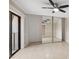 A bright bedroom features tile flooring, mirrored closet doors, a ceiling fan, and sliding glass doors to a balcony at 2722 11Th Ct # 50A, Palm Harbor, FL 34684