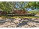 Exterior view of the condo building, surrounded by mature trees and landscaping, with dedicated parking spaces at 2722 11Th Ct # 50A, Palm Harbor, FL 34684