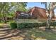 View of the condo exterior with brick and a fenced-in patio area with a screen, showcasing the natural surroundings at 2722 11Th Ct # 50A, Palm Harbor, FL 34684