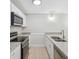 A well-lit kitchen with white cabinetry, stainless steel appliances, and granite countertops for a clean and modern feel at 2722 11Th Ct # 50A, Palm Harbor, FL 34684