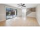 Living room with tile flooring, a staircase, and a sliding glass door leading to the patio at 2722 11Th Ct # 50A, Palm Harbor, FL 34684