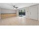 Living room with tile flooring, a ceiling fan, neutral paint, and sliding glass doors offering natural light at 2722 11Th Ct # 50A, Palm Harbor, FL 34684