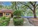 A tan office building with a brown roof is seen near a basketball court and surrounded by trees at 2722 11Th Ct # 50A, Palm Harbor, FL 34684